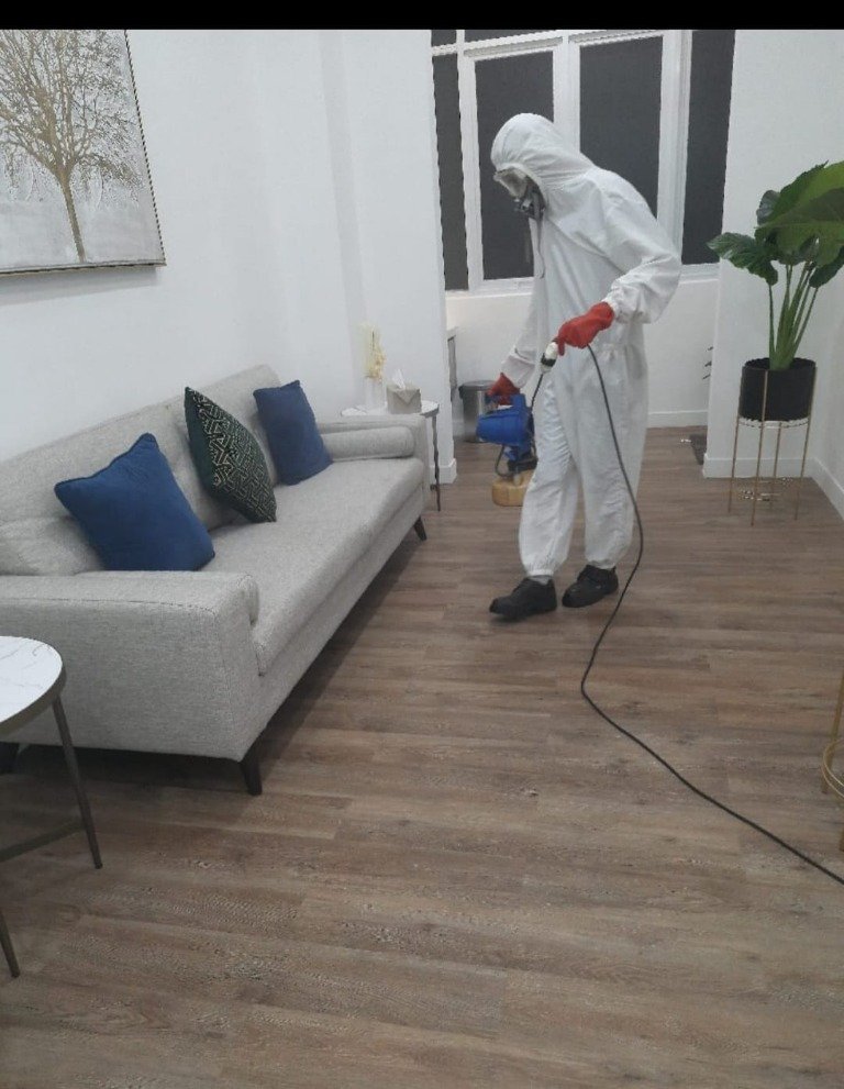 Teknisi melakukan disinfeksi ruang keluarga