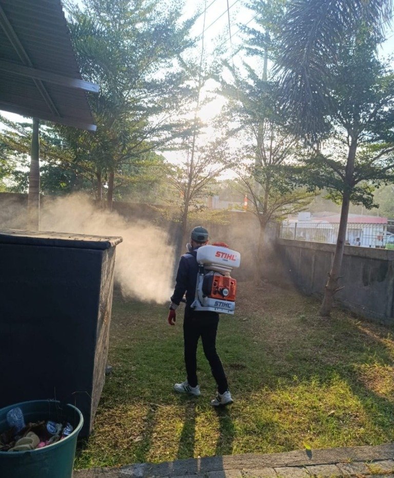 Teknisi melakukan fogging untuk pengendalian nyamuk di area terbuka